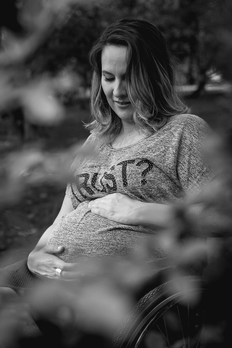 foto em preto e branco com a gestante olhando para a barriga e com as mão sobre a barriga