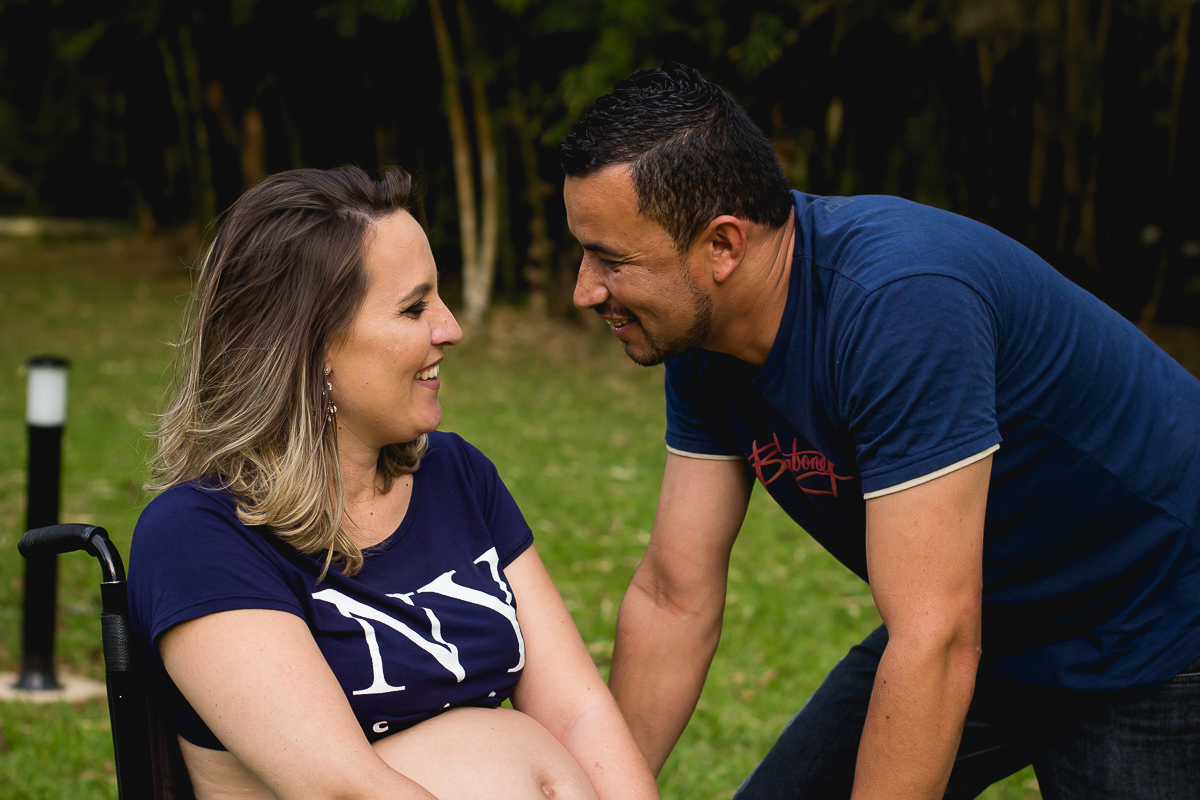 gestante cadeirante com seu marido do lado os dois se olhando e sorrindo