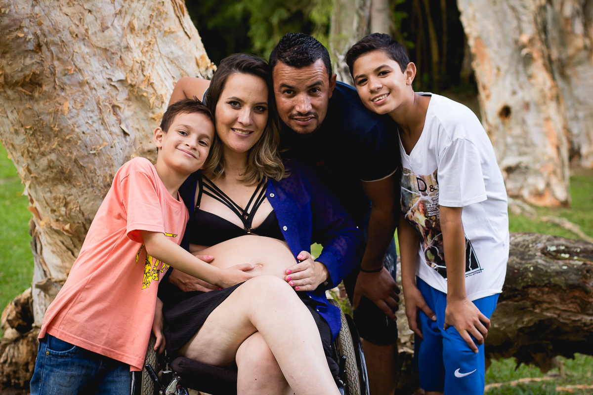 gestante de cadeira de rodas com seu marido e seu filho