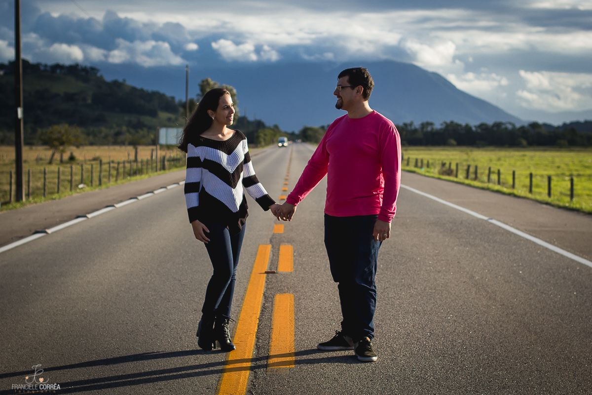 casal de mãos dadas olhando um para o outro no meio do asfalto