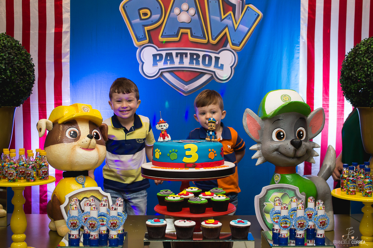 aniversariantes atrás do bolo azul com tema patrulha canina