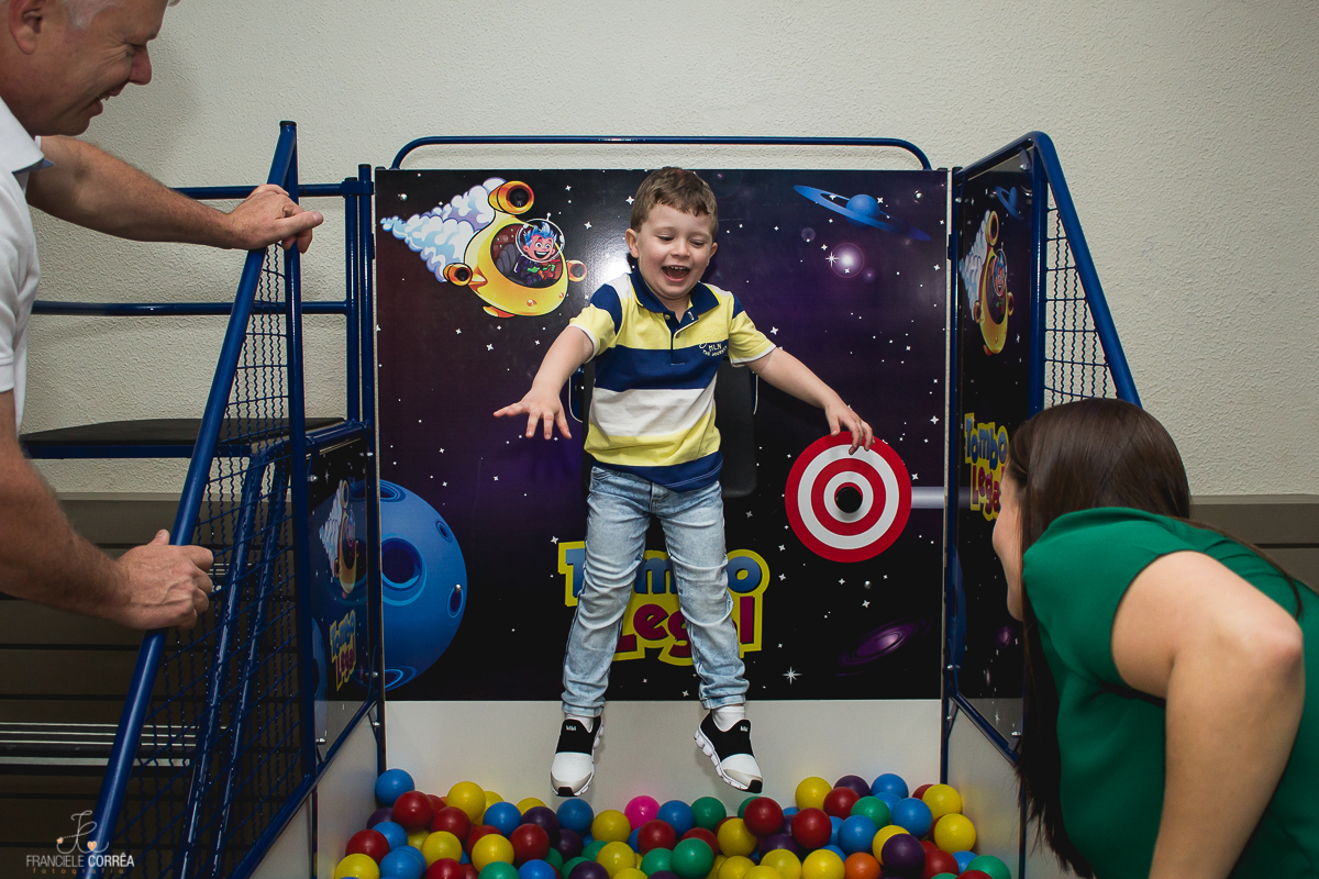 aniversariante rindo e caindo na piscina de bolinha