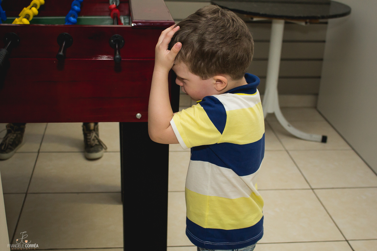 criança com a mão na cabeça