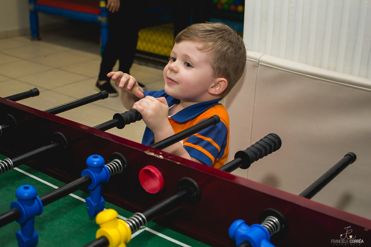 criança brincando na mesa de pimbolim