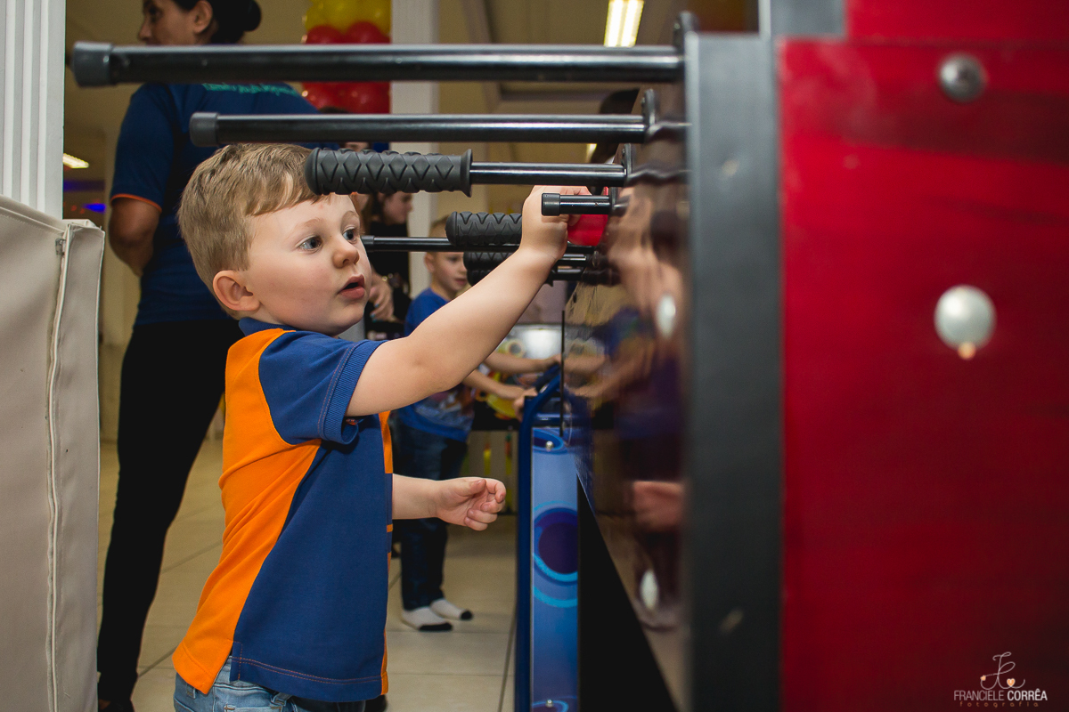 foto da criança brincando na mesa de pimbolim