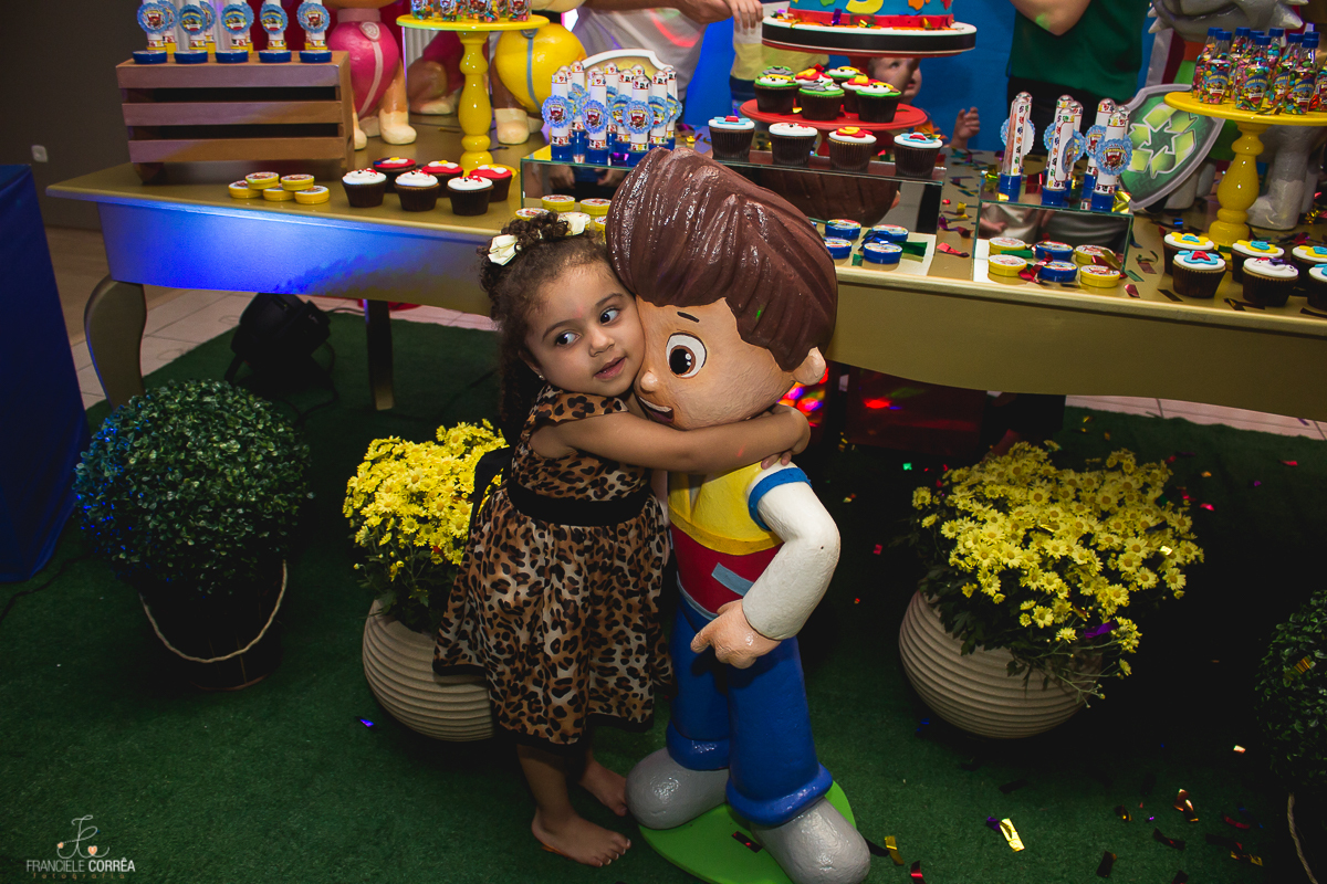 criança abraçada com o boneco de decoração o personagem Ryder da patrulha canina