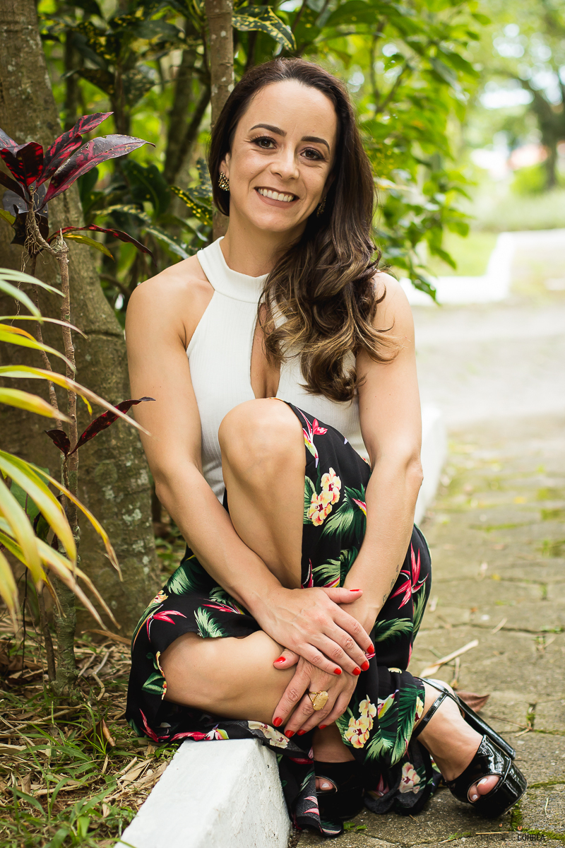 foto na vertical mulher sentada no meio fio