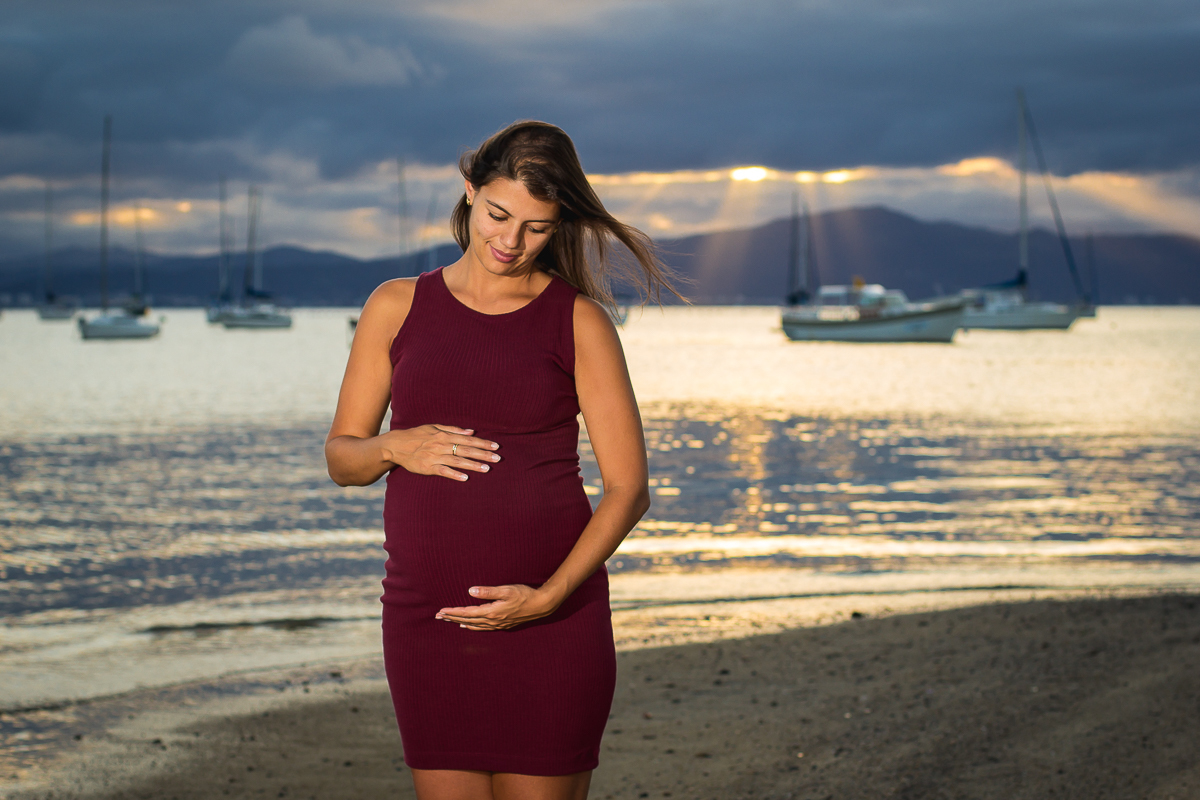 gestante olhando para barriga na beira da praia
