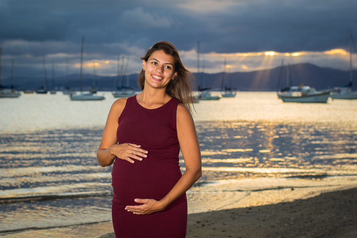 gestante sorrindo na beira da praia
