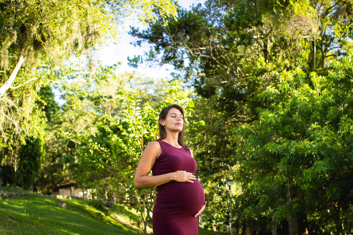gestante com as mãos na barriga de olho fechado