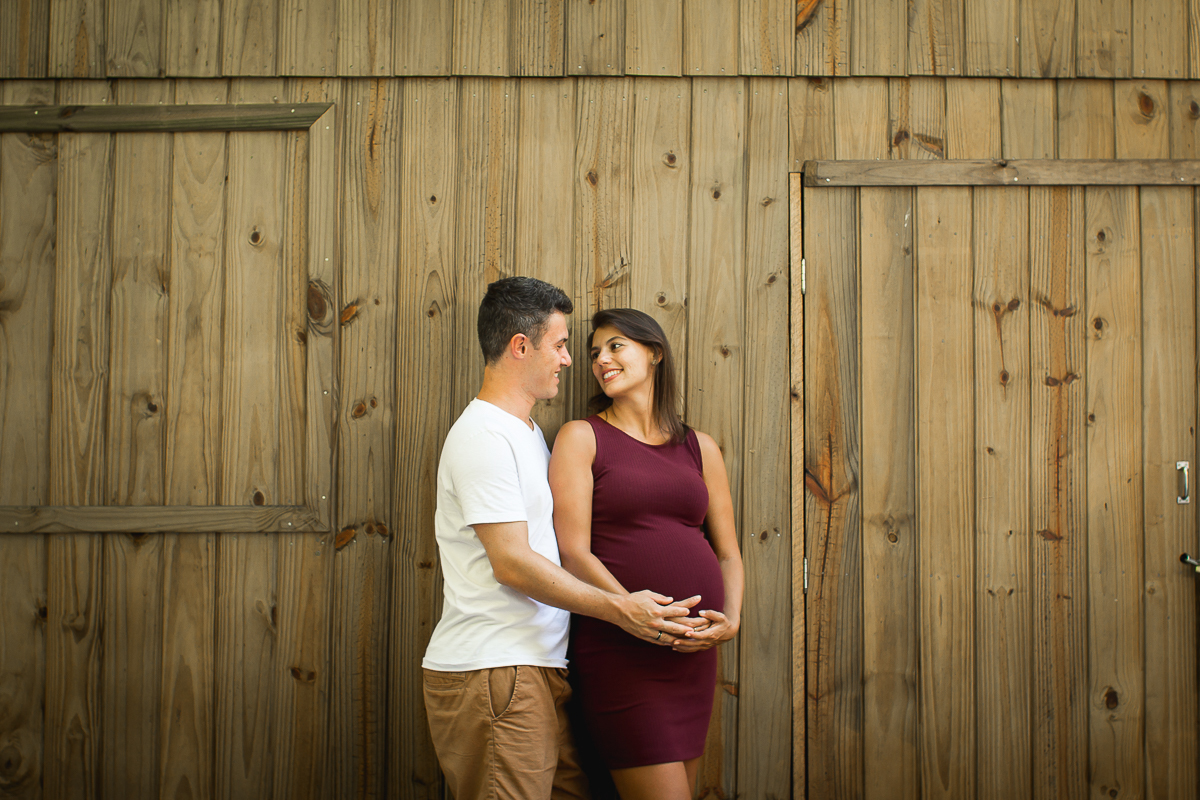 casal se olhando em frente a uma parede de madeira