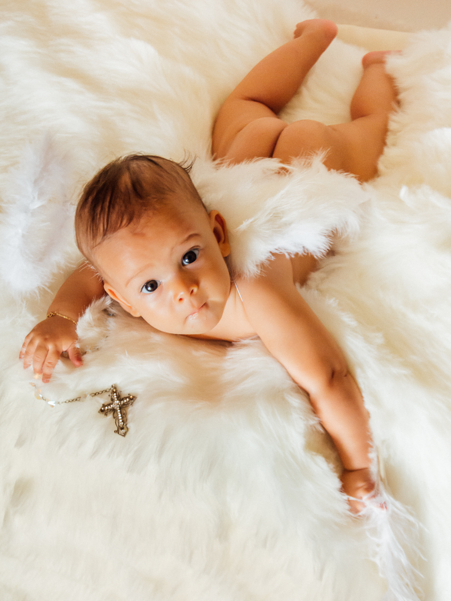 Bebê com asa de anjinho e um terço na mão simbolo do cristianismo, um bebê anjo