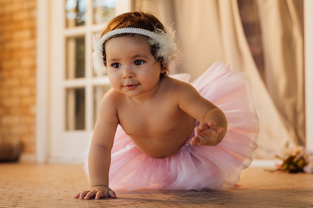 Bebê menina vestida de bailarina engatinhando