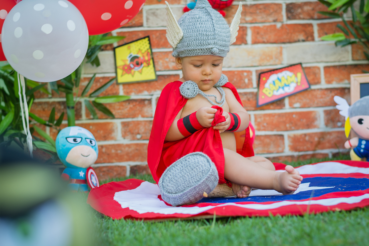 Thor bebê mexendo na capa vermelha