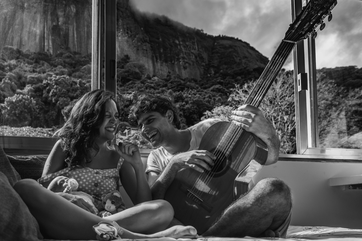 Papai e mamãe fazem o bebê dormir, estão sentando em cima da cama, a mamãe embala o bebê enquanto o papai toca o violão e canta musicas de ninar acompanhando a letra pelo celular, papai e mão dão risadas.
Ao fundo, vista do quarto para o corcovado.