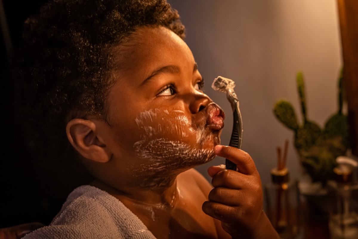 Criança aprendendo a fazer a barba com o pai