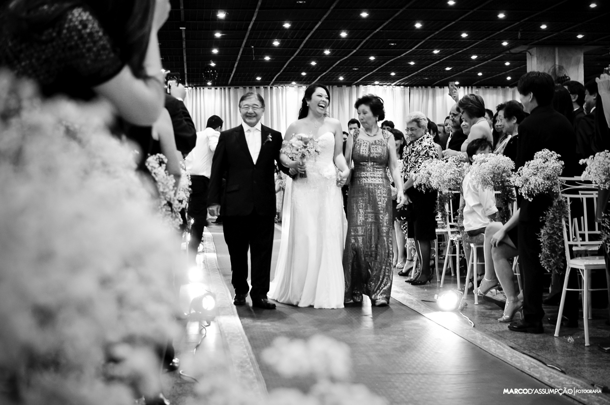 noiva entra com os pais durante cerimonia