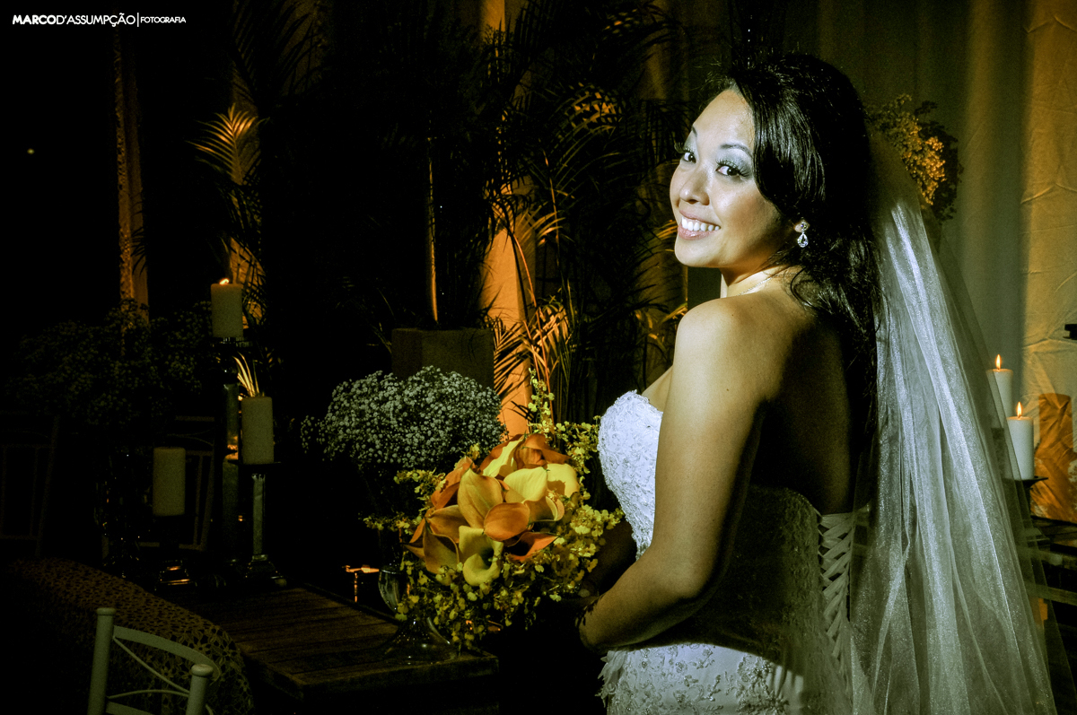 noiva segurando o buque com flores e luzes ao fundo