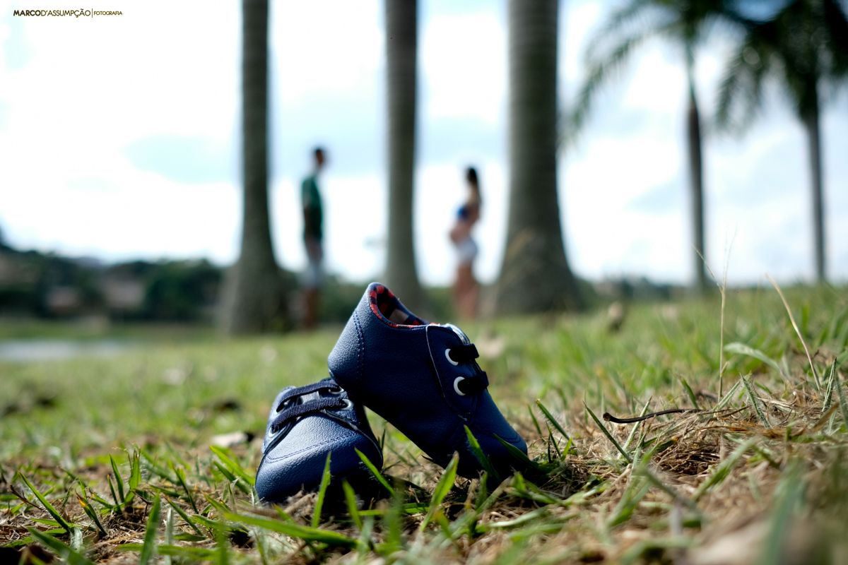 sapatinho de bebe com os pais ao fundo