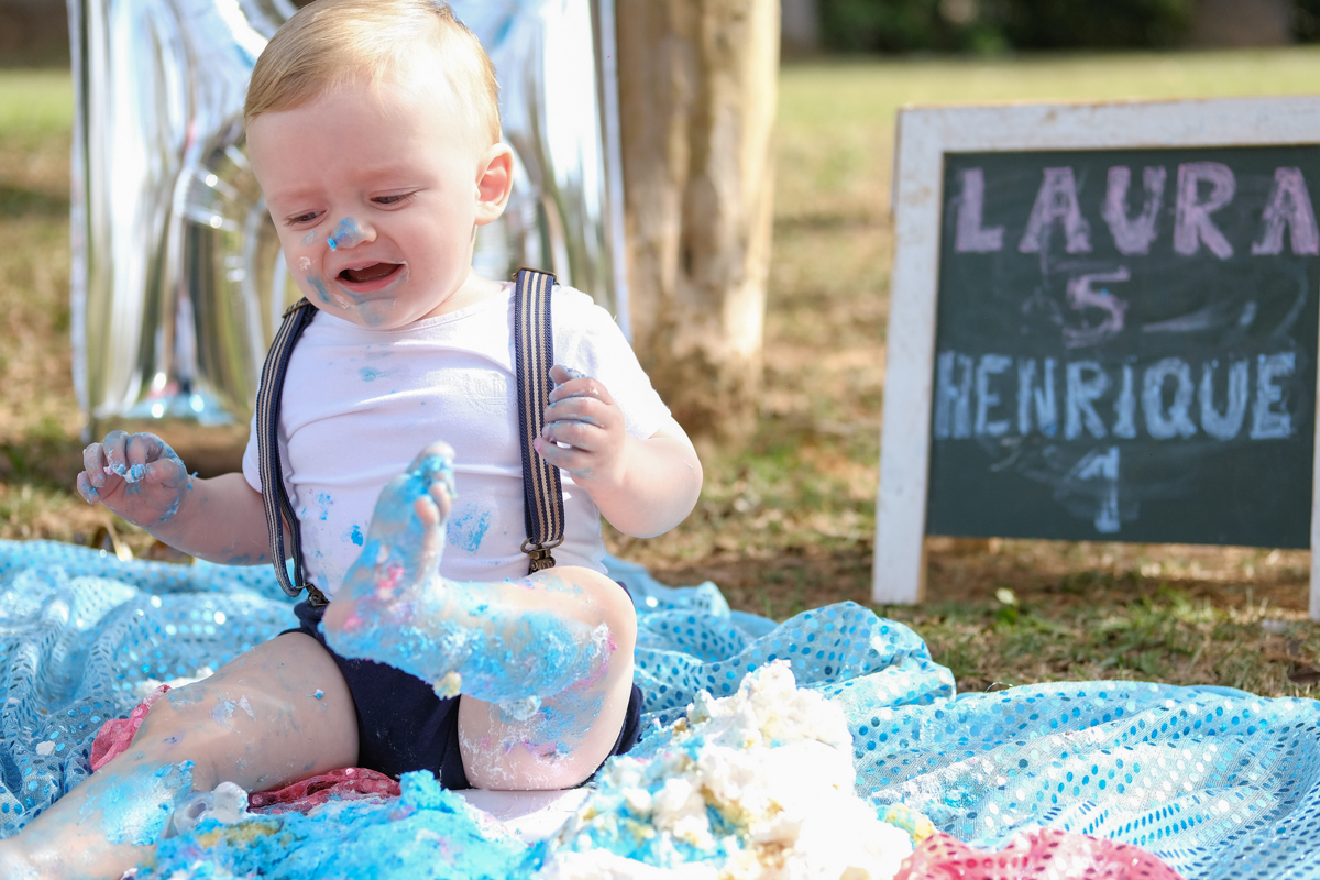 bebe pisando em bolo de aniversário no ensaio