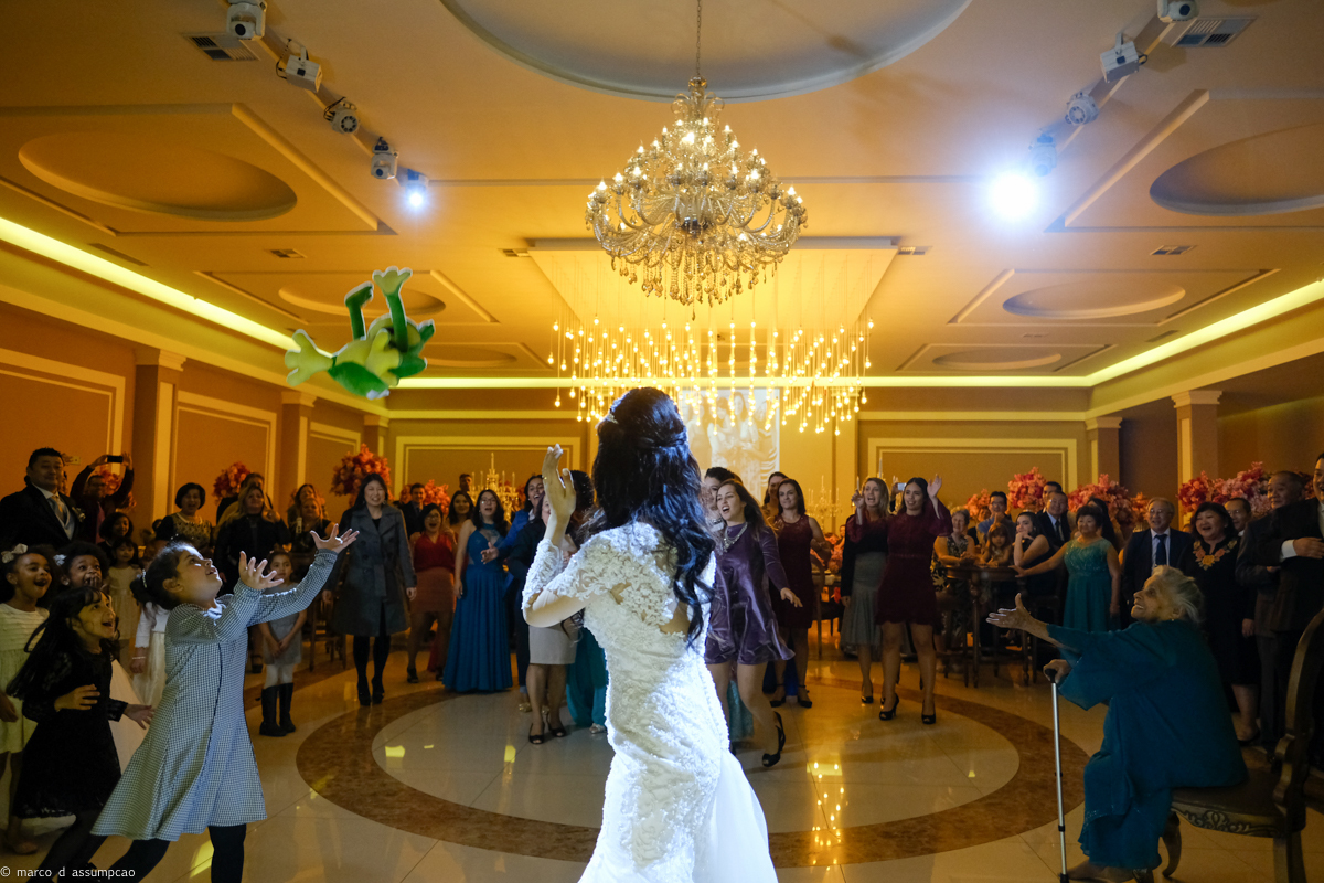 noiva jogando uma pelucia de sapinho e crianca correndo atras