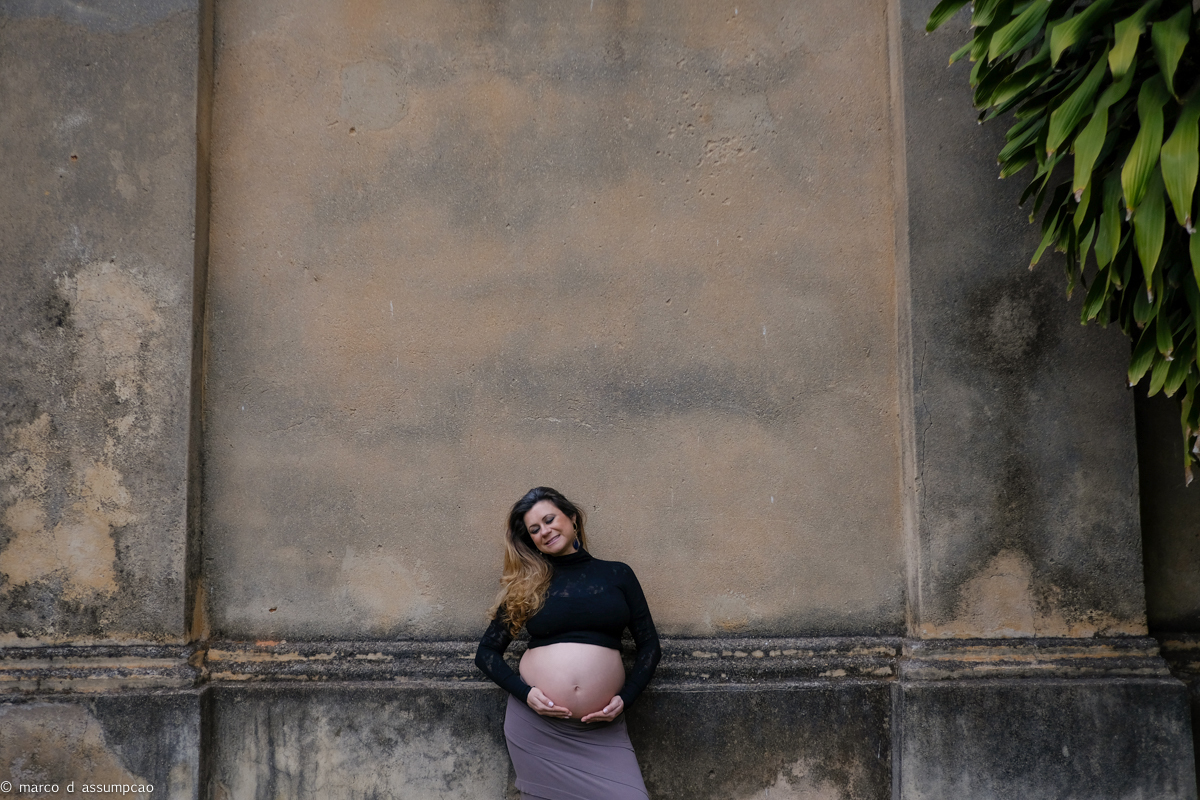 gestante encostada na parede de igreja antiga