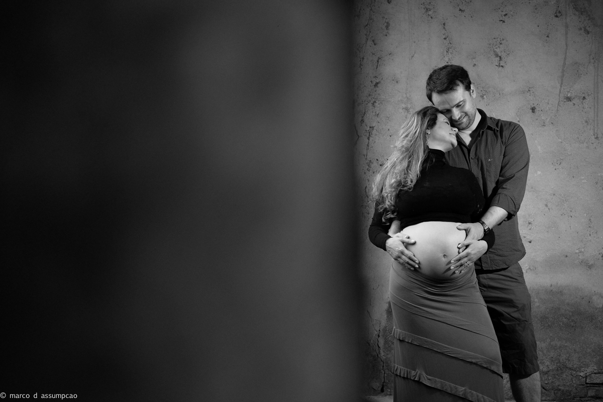 casal se abraçando ao lado de janela em construção antiga