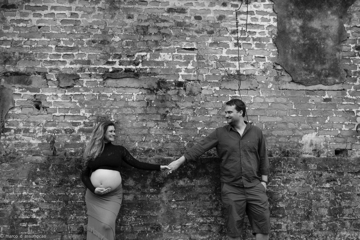 casal encostado em parede antiga de igreja