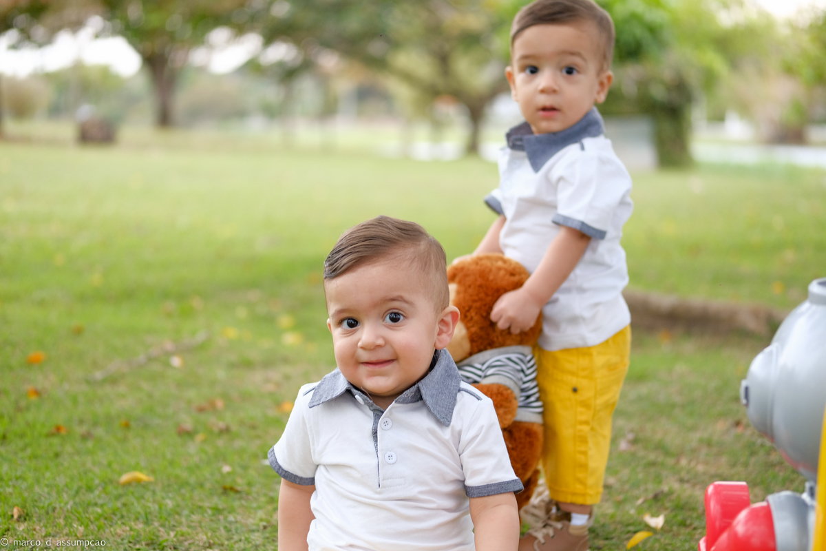 irmaos brincando na grama com seus brinquedos