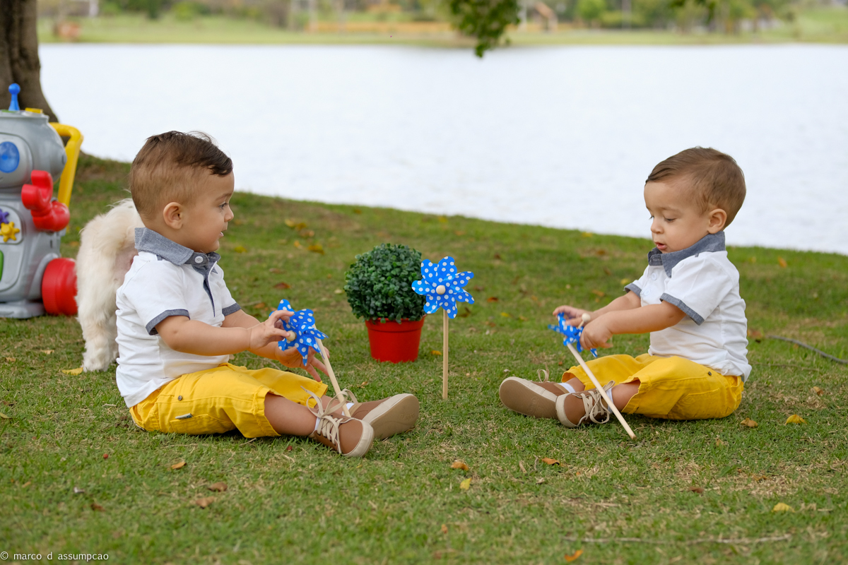 irmaos brincando na grama com seus brinquedos