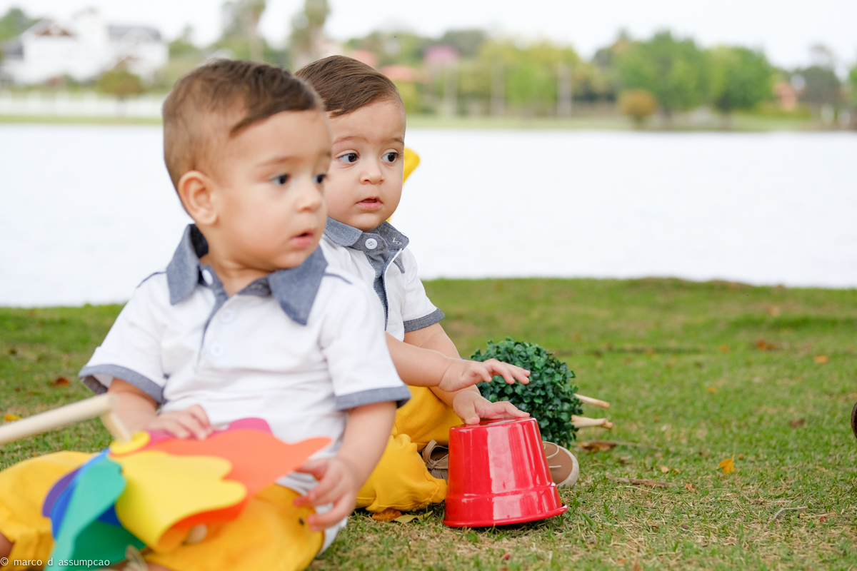 irmaos brincando na grama com seus brinquedos