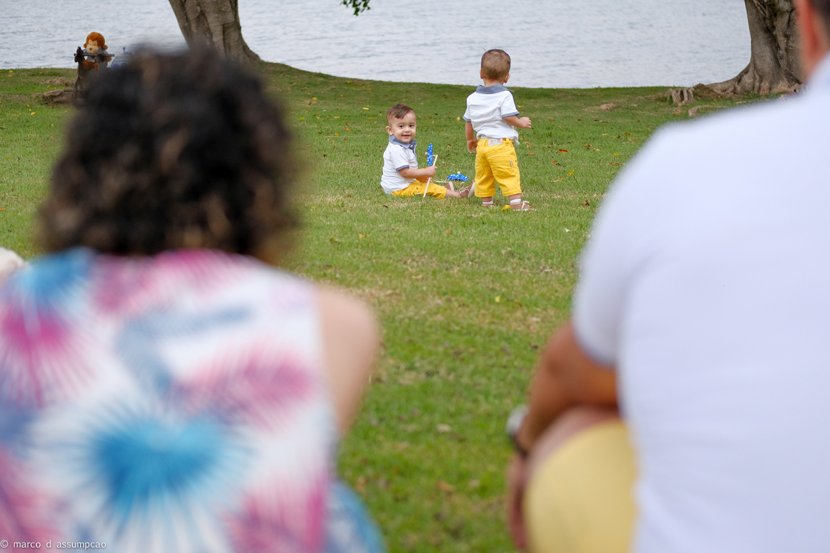 irmaos brincando na grama com seus brinquedos