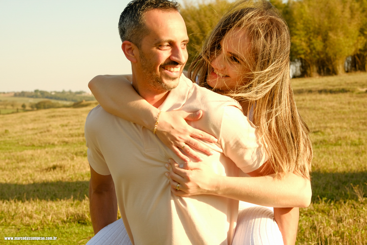 noiva apoiada nas costas do seu noivo sorrindo