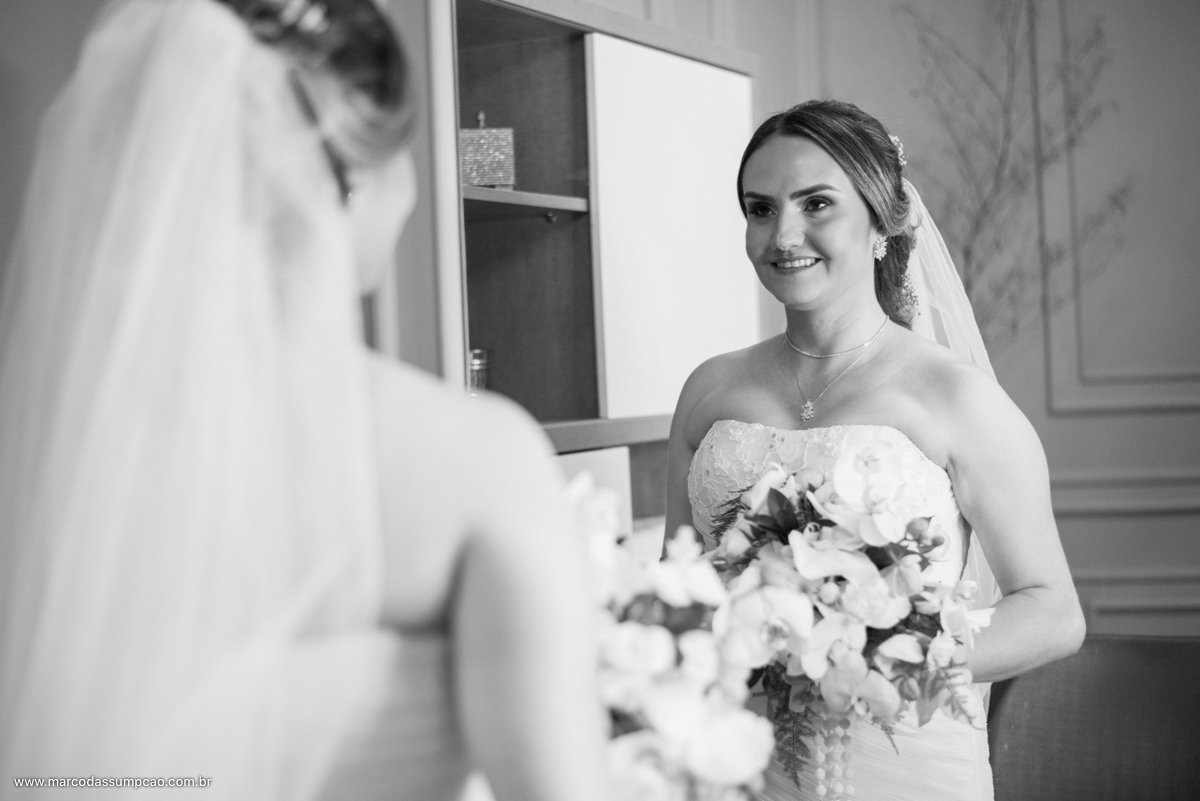 noiva segurando o buque se olhando no espelho