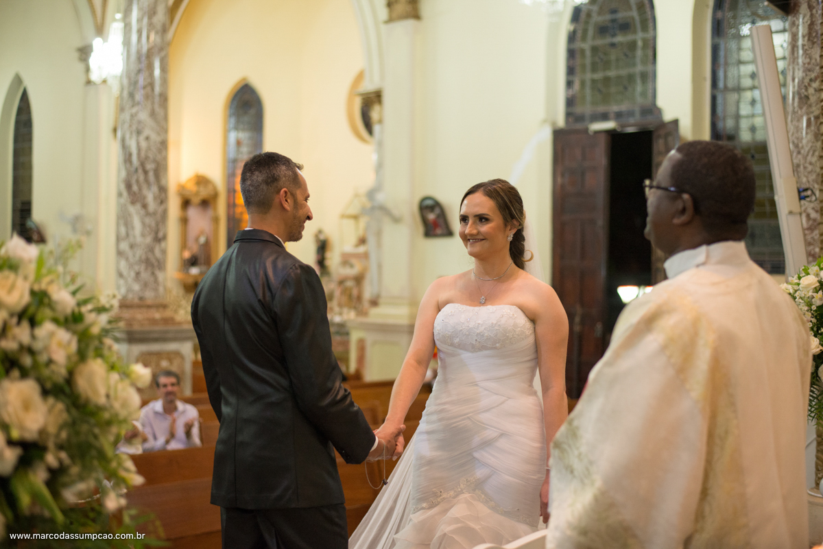 noivos de maos dadas se olhando no altar