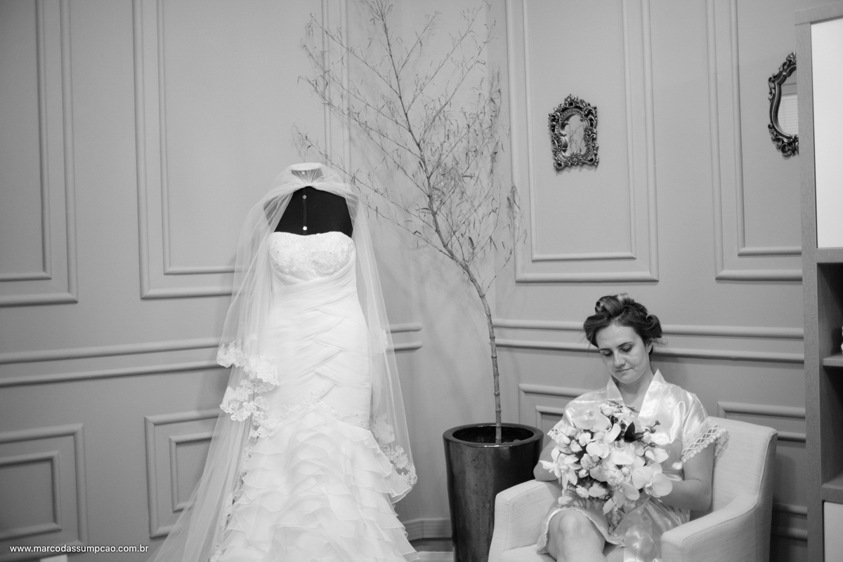 noiva sentada segurando o buque com vestido ao seu lado