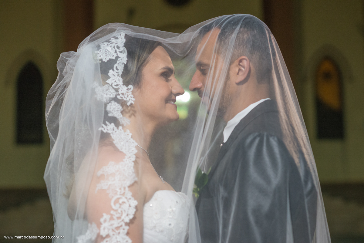 noivos sorrindo em frente a igreja