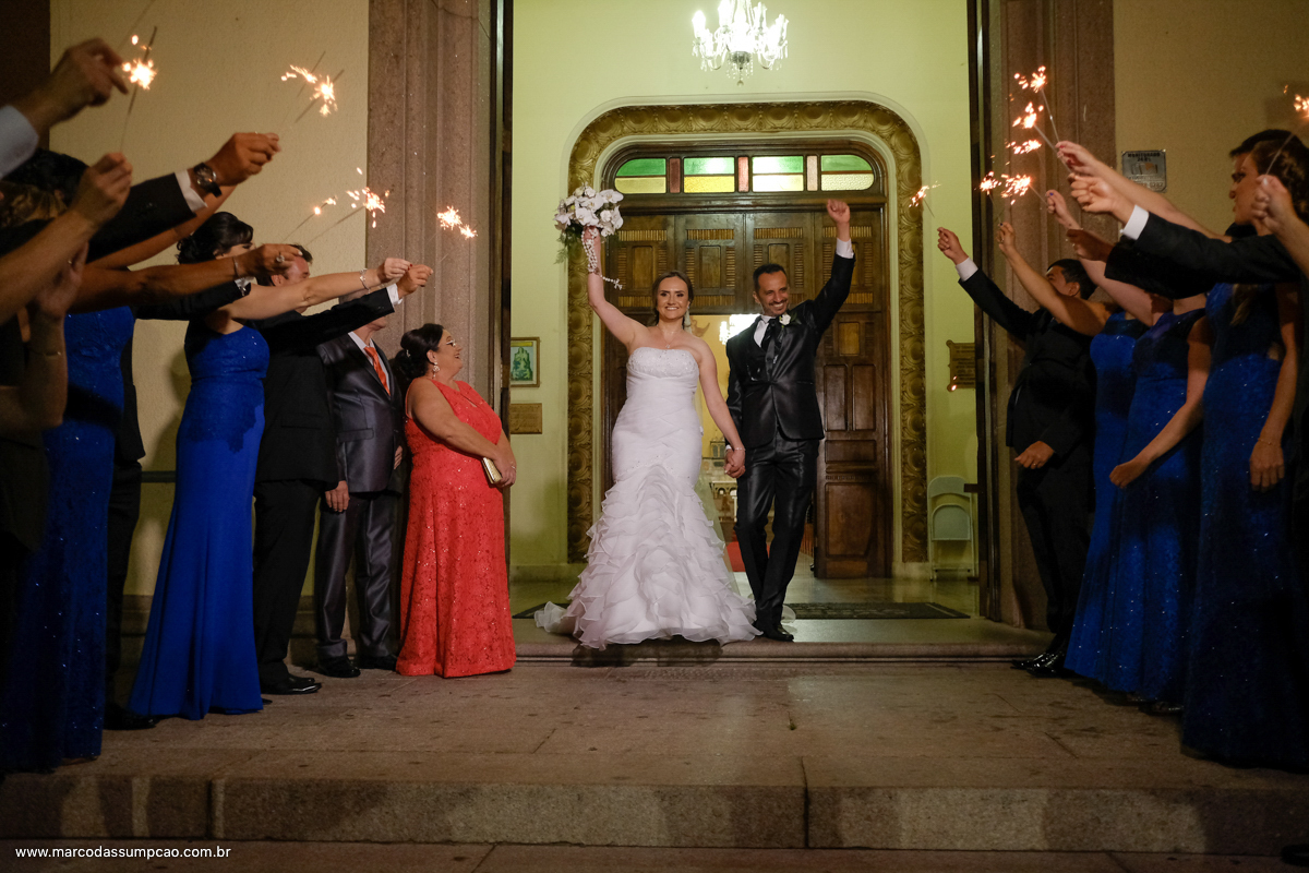 noivos sendo recebidos pelos padrinhos com velas avesas