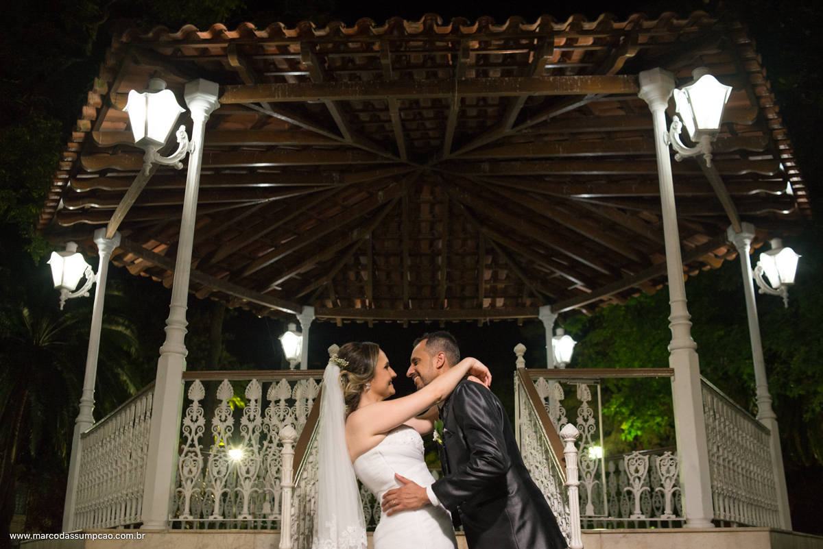 noivos se abraçando em frente a escada do coreto.