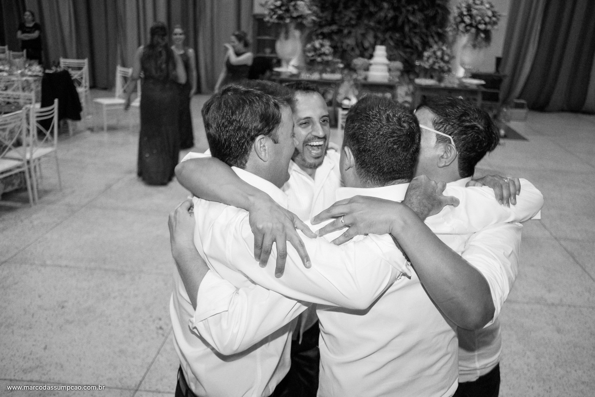 amigos se abracando durante a festa de casamento em foto preto e branco