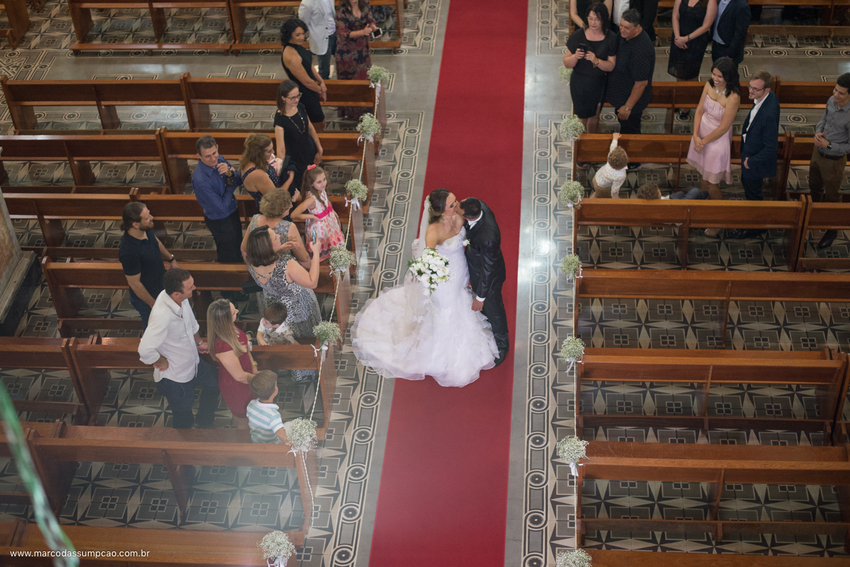 noivos se beijando no corredor da igreja 