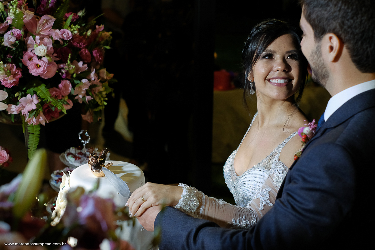 noivos cortando o bolo de casamento e se olhando