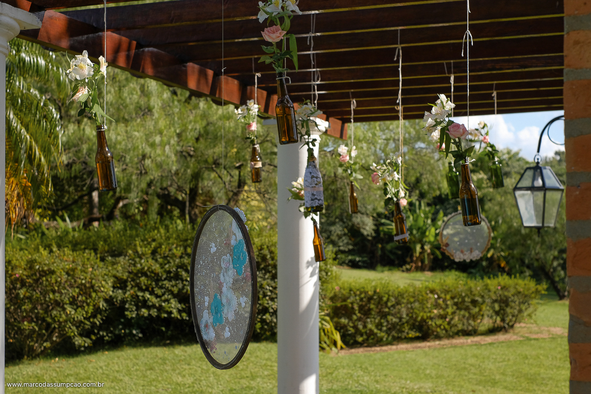 garrafas penduradas com flores no pergolado