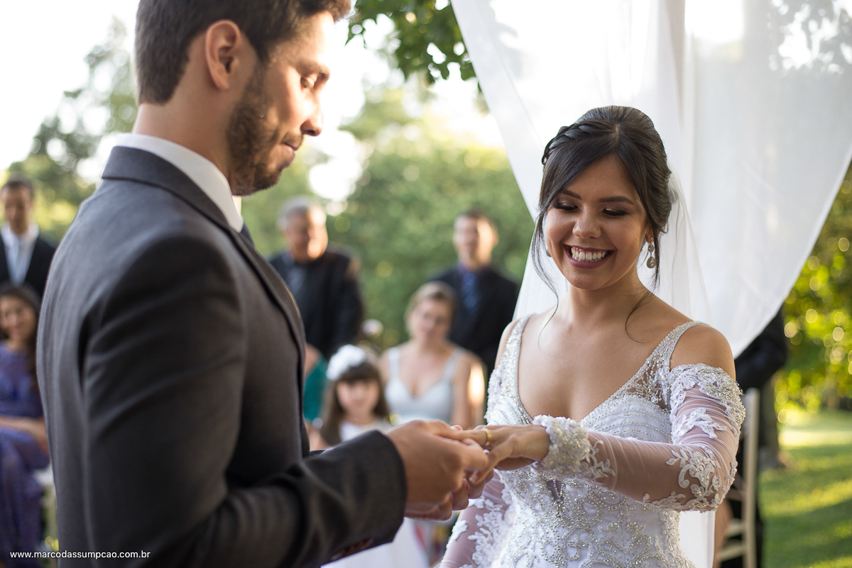 noivo colocando as aliancas na mao da noiva