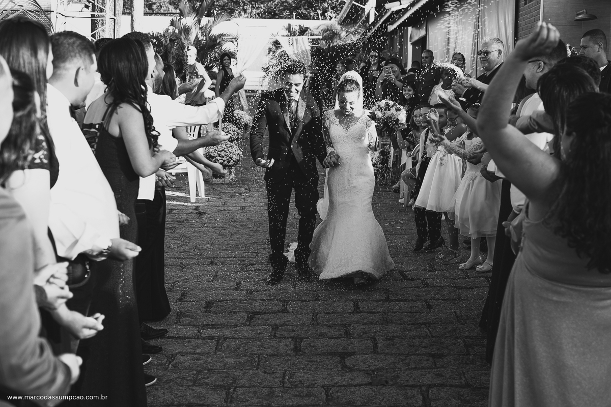 noivos saindo da cerimonia e os padrinhos jogando arroz
