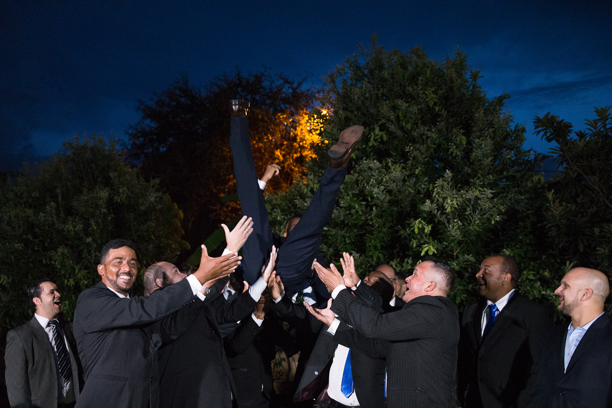 noivo sendo jogado pra cima com as pernas para o alto