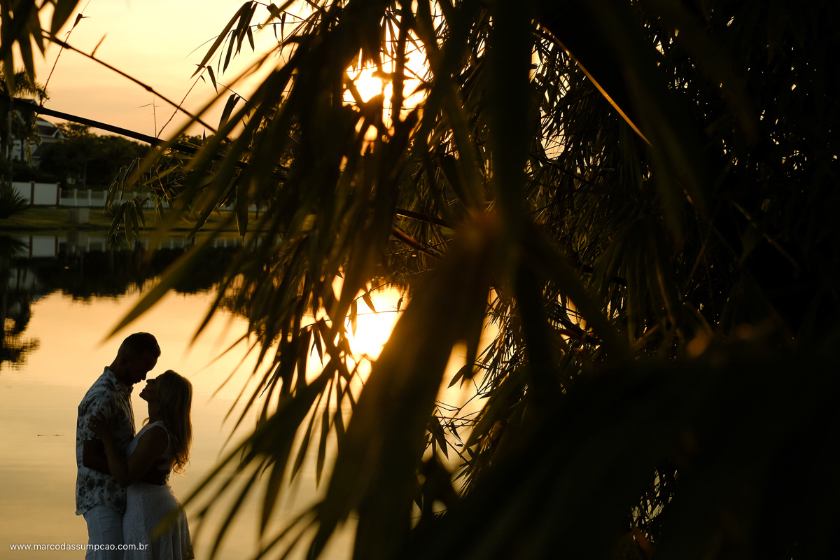 casal abracados no por do sol em um lago