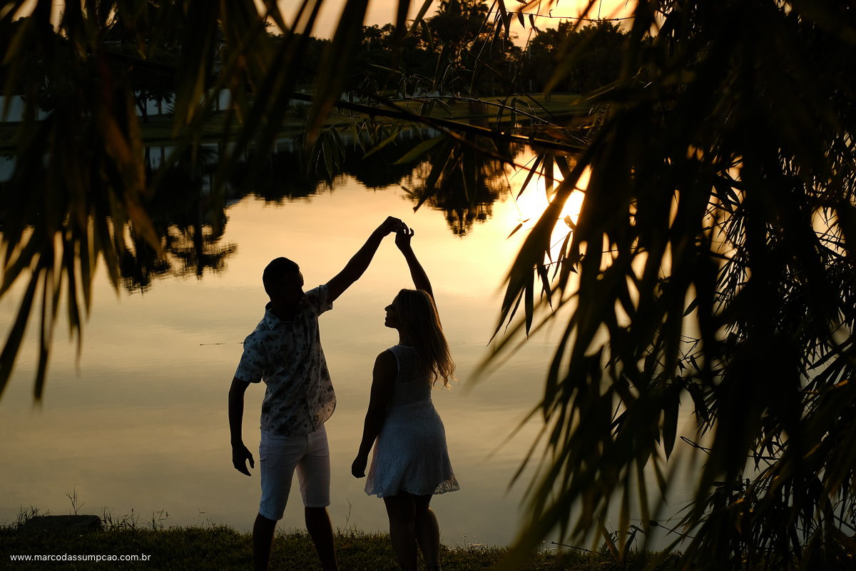 casal dancando no por do sol em frente ao lago