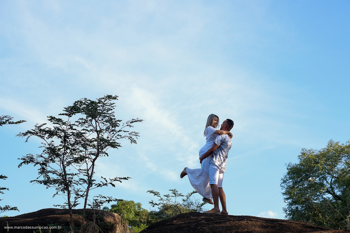 casal em cima de uma pedreira com a mulher abracada no pescoco do homem