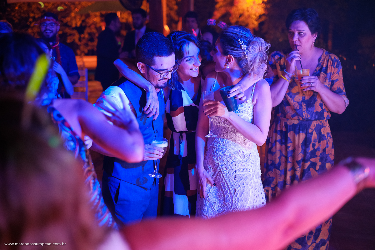noivos curtinso e sendo abracados durante a balada